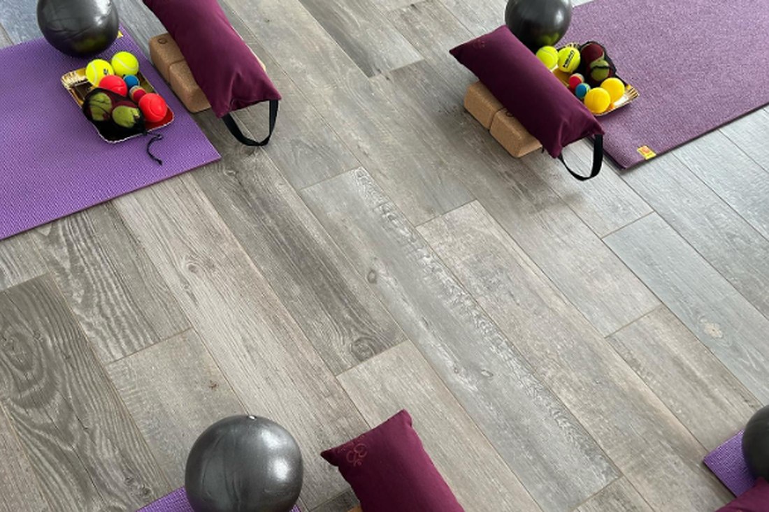 Des tapis de yoga vus de haut, avec briques, bolsters et petites balles de massage