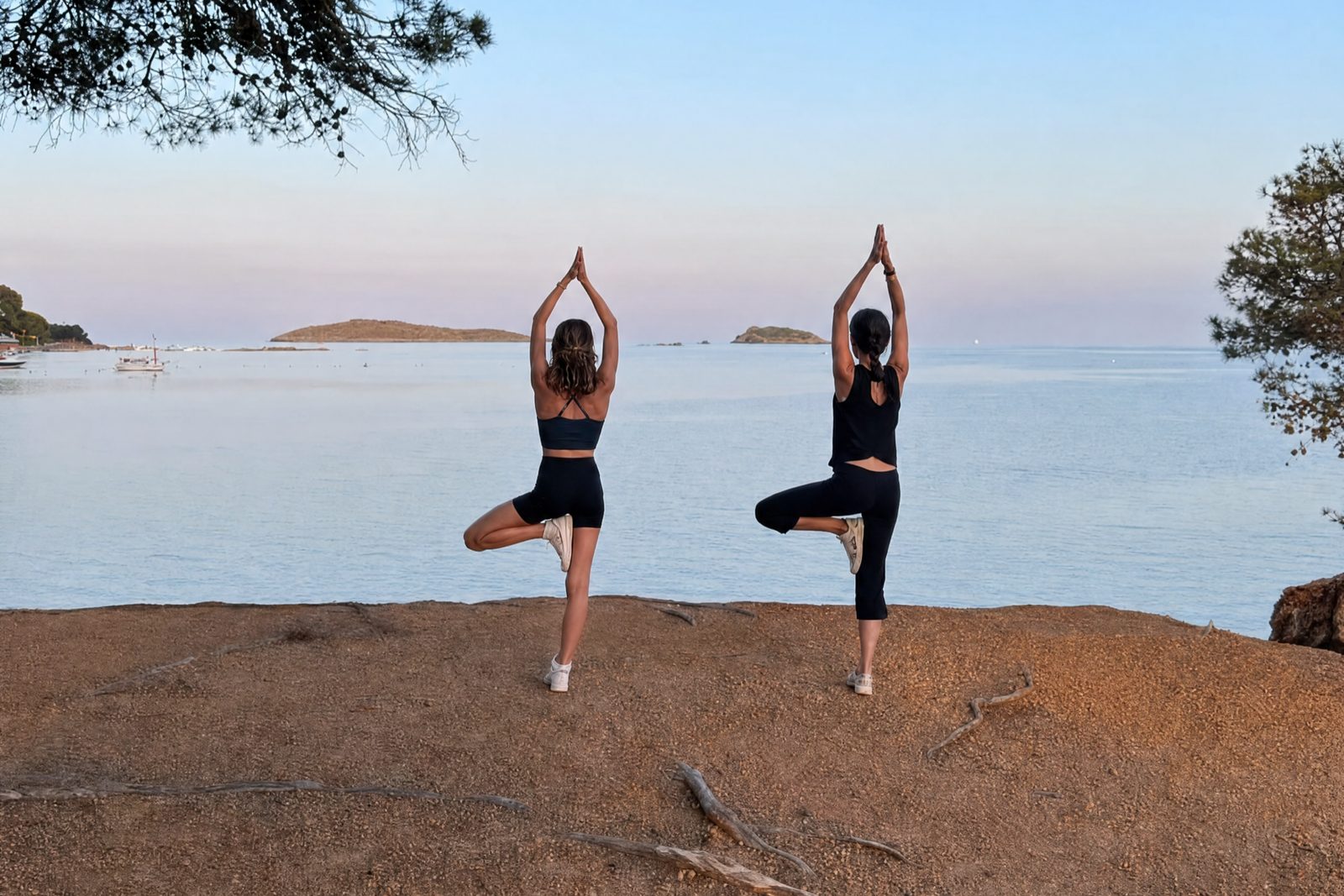Angie et sa fille en posture de l’arbre au bord de la mer, au crépuscule